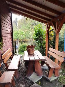 stół piknikowy i dwie ławki w szopie w obiekcie Noclegi u Barbary w mieście Nasiczne