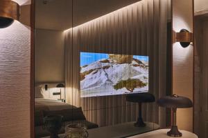 a bedroom with a tv on a wall with a bed at Prim&Proper in Porto