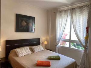 een slaapkamer met een bed met twee handdoeken erop bij Acogedor apartamento cerca de la playa in Los Alcázares