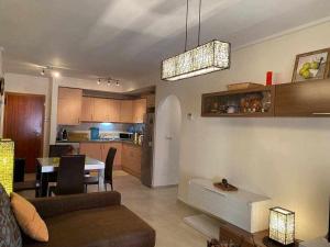 een woonkamer en een keuken met een bank en een tafel bij Acogedor apartamento cerca de la playa in Los Alcázares