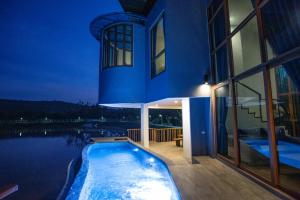 uma casa com piscina em frente a um edifício em Phurua Sanctuary Resort and Spa em Phu Rua