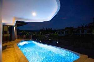 a moon over a swimming pool at night at Phurua Sanctuary Resort and Spa in Phu Ruea