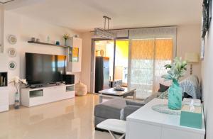 uma sala de estar com um sofá e uma televisão em Apartamento Puerta del Sol em Conil de la Frontera