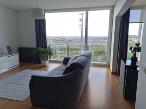 a living room with a couch and a large window at Alto das Marinhas in Aveiro