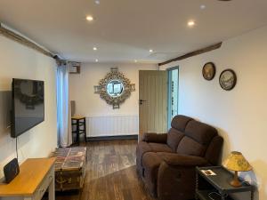 a living room with a couch and a tv at Middle Tree, ideal modern cottage in Alburgh