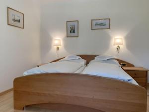 1 Schlafzimmer mit 2 Betten und 2 Lampen an der Wand in der Unterkunft Belvilla in Dorf Tirol