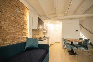 a living room with a couch and a brick wall at Dimora Ca Gambari-Chioggia in Chioggia
