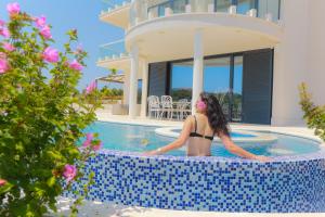 a woman in a bikini standing in a swimming pool at Perla Resort in Rogoznica