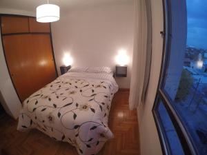 a small bedroom with a bed and a window at Departamento 37 in La Plata