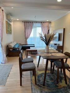 SNHomestay1826 Sea View @ The Wave Residence في ميلاكا: غرفة معيشة مع طاولة وكراسي وأريكة