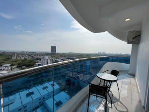 - Balcón con mesa y sillas en un edificio en SNHomestay1826 Sea View @ The Wave Residence, en Melaka