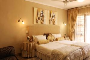 a bedroom with two beds and a window at Villa Ticino Guest House in Sabie
