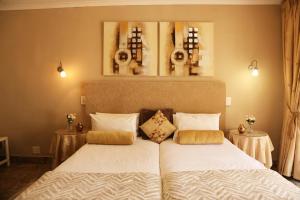 a bedroom with two beds and two tables at Villa Ticino Guest House in Sabie