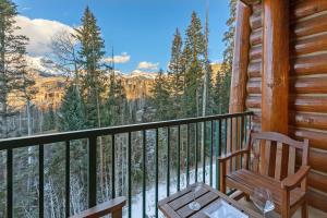 a rocking chair on a balcony with a view of the mountains at Have It All Ski in out Affordable Too in Telluride
