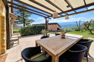 einen Holztisch und Stühle auf einer Terrasse in der Unterkunft Villa Pilotti Country House in Penna San Giovanni