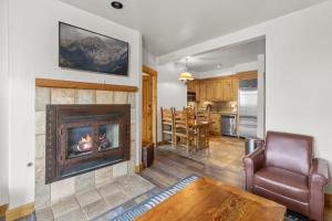 a living room with a fireplace and a kitchen at Have It All Ski in out Affordable Too in Telluride