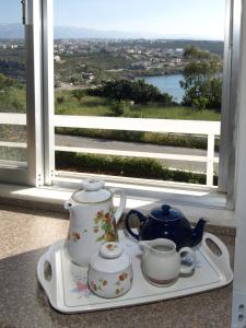 a tray with two cups and a tea set in front of a window at Villas Michalis in Chorafakia