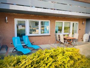 d'une terrasse avec des chaises et une table. dans l'établissement FeWo STRANDGUT- Familien - Hunde - strandnah - eigene Terrasse - Sauna & Wellness, à Sierksdorf