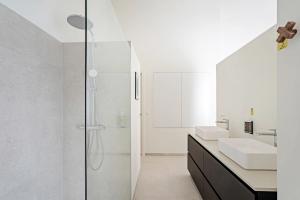 a white bathroom with a shower and a sink at Smartflats - Bell Tower Ghent in Ghent