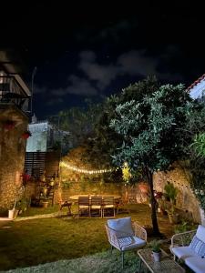 una mesa y sillas en un patio por la noche en Casa La Bohema, en Afitos
