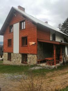 Cette grande maison en bois possède une terrasse couverte. dans l'établissement Noclegi Na Smaguli, à Korbielów
