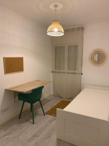 um quarto com uma mesa, uma cama e um candeeiro em Carcavelos beach walking distance room in shared apartment em Oeiras