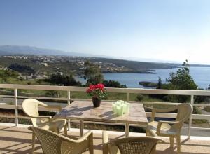 a table and chairs on a balcony with a view of the water at Villas Michalis in Chorafakia