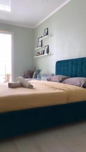 a large bed with a blue headboard in a room at Nur 5 in Uralsk