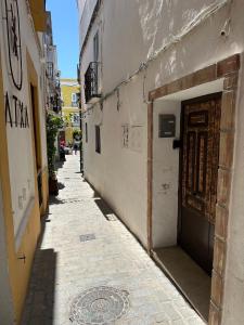 a narrow alley with a door in a building at Apartment in old town with roof terrace and fibre, Tarifa in Tarifa