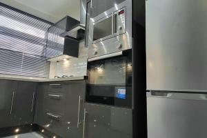 uma cozinha com utensílios de aço inoxidável e uma janela em Cosy 3 double bed flat sleeps 6 em Bedworth