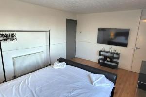 a bedroom with a bed and a flat screen tv at Cosy 3 double bed flat sleeps 6 in Bedworth