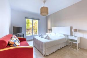 - une chambre avec un lit et une chaise rouge dans l'établissement Apartamento Guadalmina Golf l, à Marbella