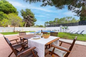 a patio with a table and chairs and a pool at Acogedora Villa en Alicante capital con barbacoa in Alicante