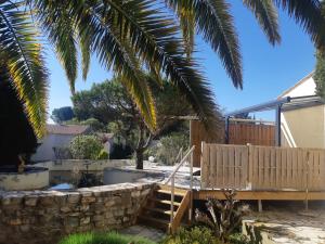 a backyard with a wooden staircase and a stone wall at Le Mas Blanc in Carcassonne