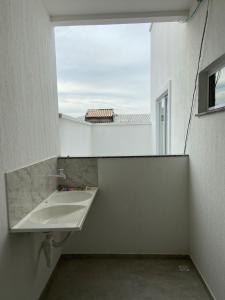 a bathroom with a sink and a window at ARCO IRIS KITNETS in Fortaleza