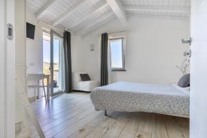 ein weißes Schlafzimmer mit einem Bett und einem Fenster in der Unterkunft Dolce Dormire Suite in Arcola