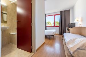 a hotel room with two beds and a bathroom at Hotel Basic in Vilafranca del Penedès