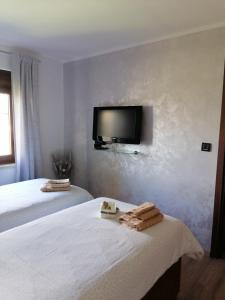 a bedroom with two beds and a tv on the wall at Apartment Grbin in Pula