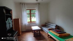 ein Wohnzimmer mit einem Sofa und einem Tisch in der Unterkunft Osada Włościańska in Ojców