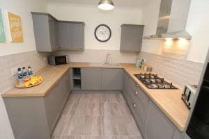 a kitchen with a sink and a clock on the wall at The Cottage IH3ATL in Stockton-on-Tees