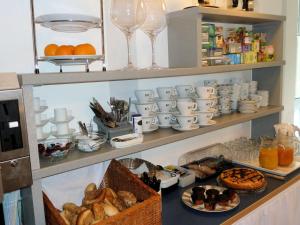 uma prateleira com copos e pratos de comida e bebidas em Gästehaus Brütting 