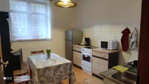 eine kleine Küche mit einem Tisch und einer Mikrowelle in der Unterkunft Osada Włościańska in Ojców