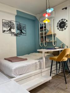 ein Schlafzimmer mit einem Bett, einem Schreibtisch und einer Uhr in der Unterkunft Oikiastudios in Patras