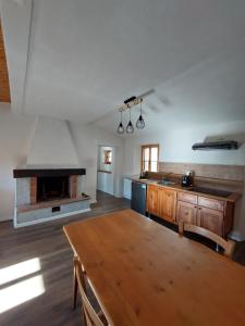 une cuisine avec une cheminée et une table en bois dans l'établissement Bruni Apartments Arcidosso - Ginevra, à Arcidosso