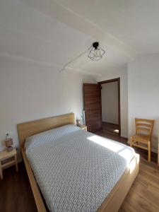 - une chambre avec un lit et une chaise dans l'établissement Bruni Apartments Arcidosso - Ginevra, à Arcidosso