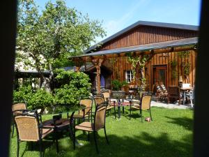 eine Terrasse mit einem Tisch und Stühlen im Gras in der Unterkunft Pension Auf der Olk mit Röpertsmühle in Veldenz