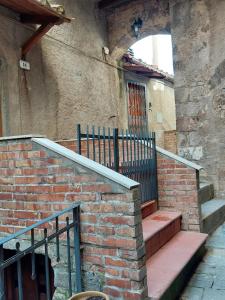 - un bâtiment en briques avec des escaliers menant à une porte dans l'établissement Bruni Apartments Arcidosso - Ginevra, à Arcidosso