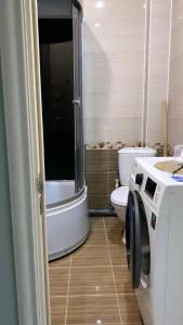 a bathroom with a toilet and a sink and a washing machine at Nur 5 in Uralsk