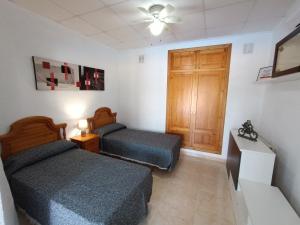 a bedroom with two beds and a wooden door at Villa Noemi, con piscina privada in Calpe