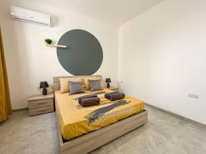 a bedroom with a large bed with a yellow blanket at 1 Bedroom Penthouse in Gzira in Il-Gżira